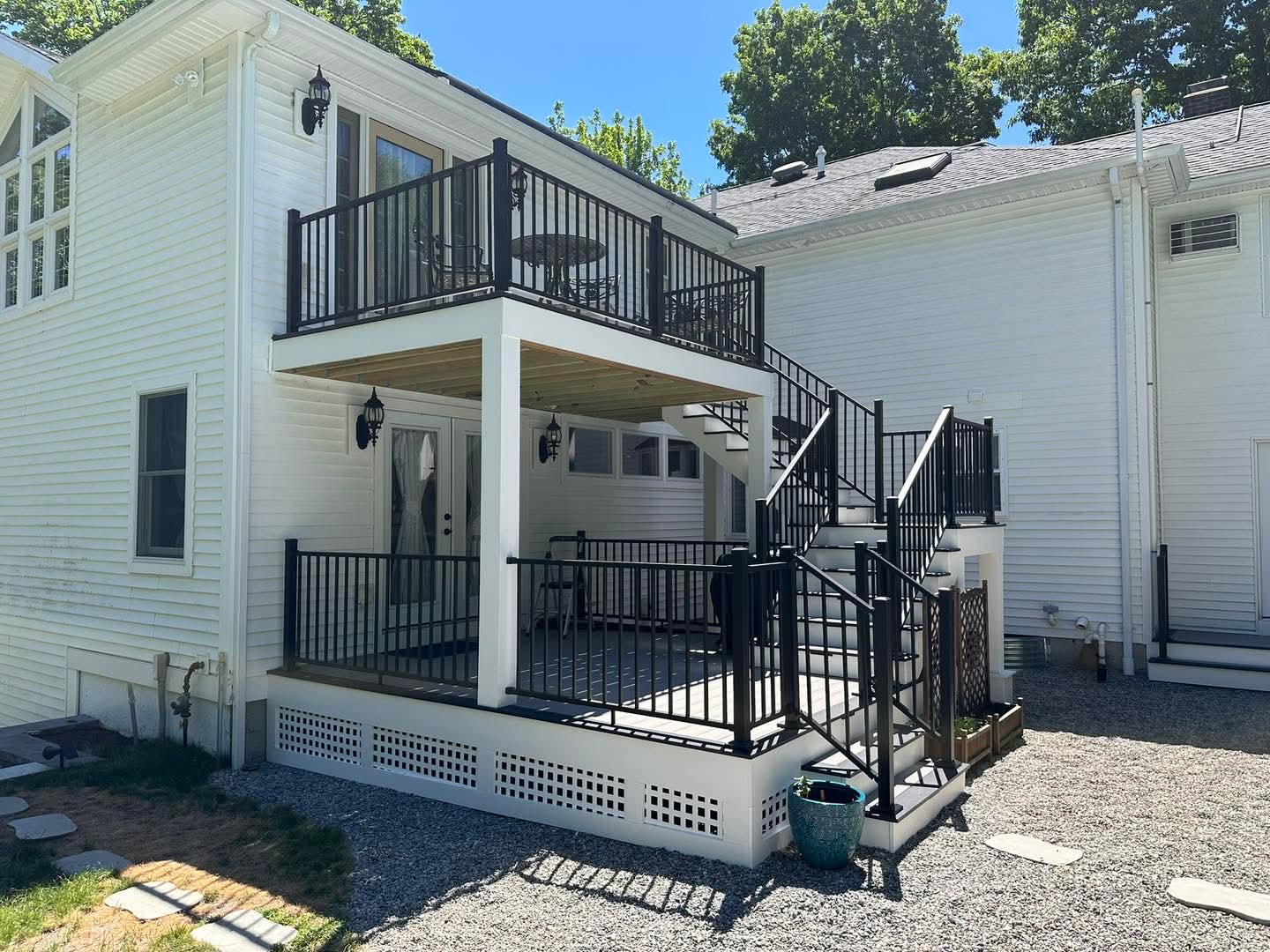 Finished two-level deck with covered porch below and black aluminum railings above
