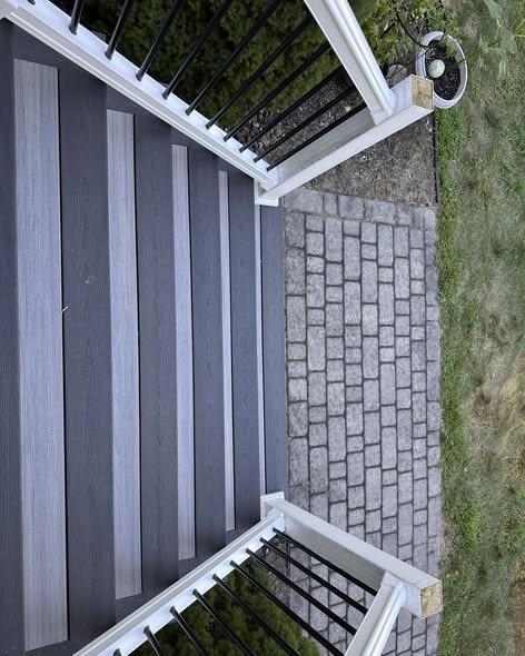 Close-up of Fiberon Chai composite porch decking with Earl Grey border and white railing with black round balusters