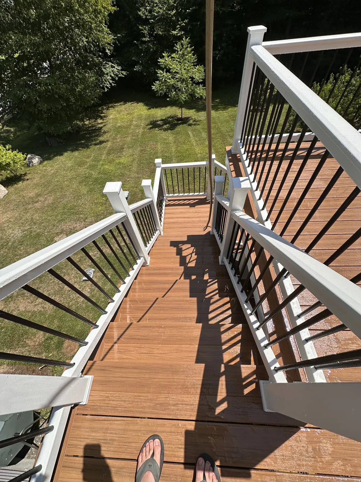 View down a switchback stair landing from an elevated composite deck in Kingston, NH