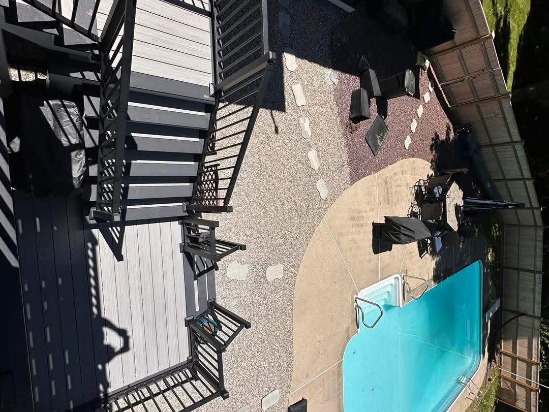 Overhead view of a two-level composite deck and stair run beside a pool patio