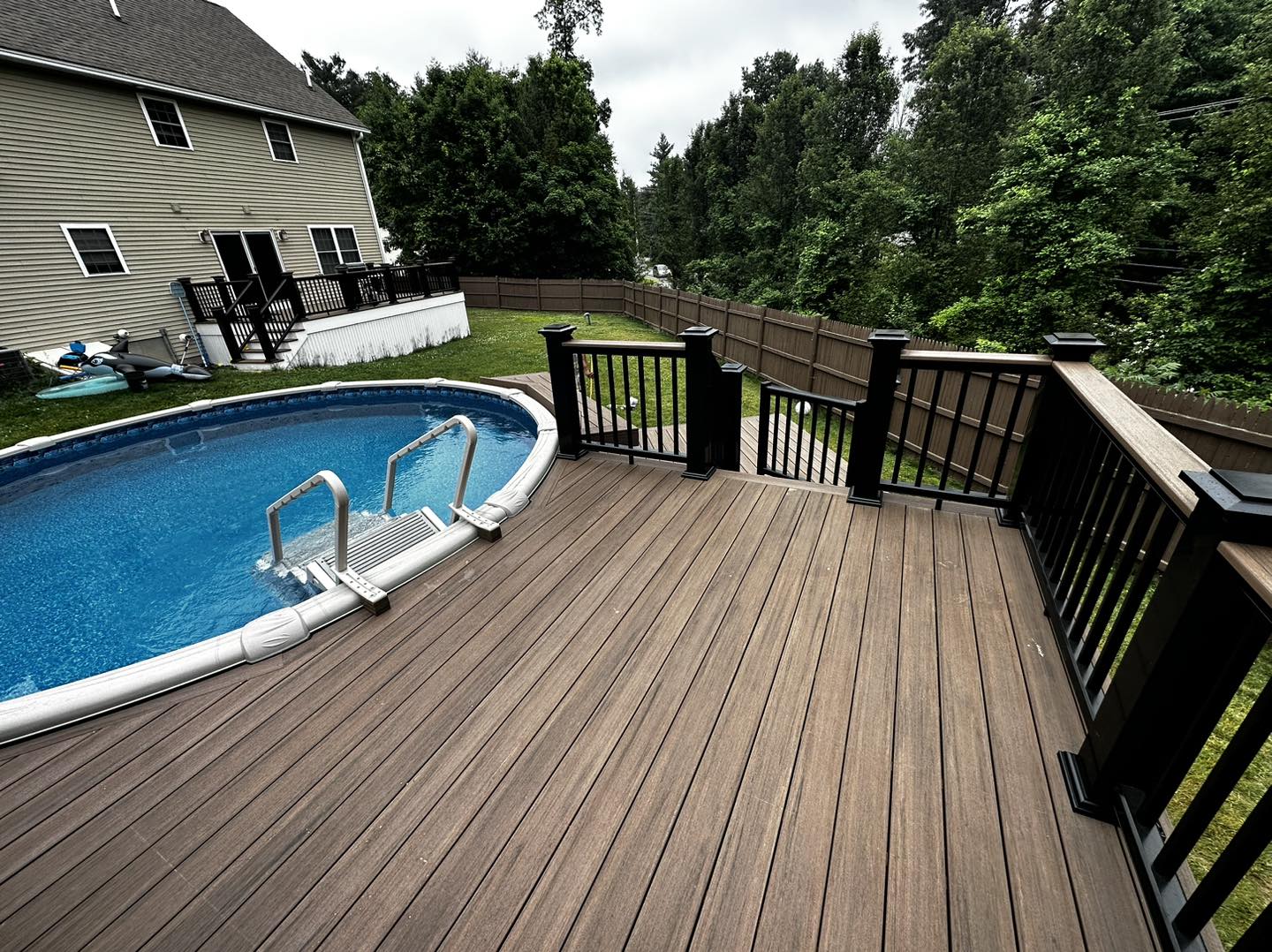 Quiet composite deck lounge area off the back of a home