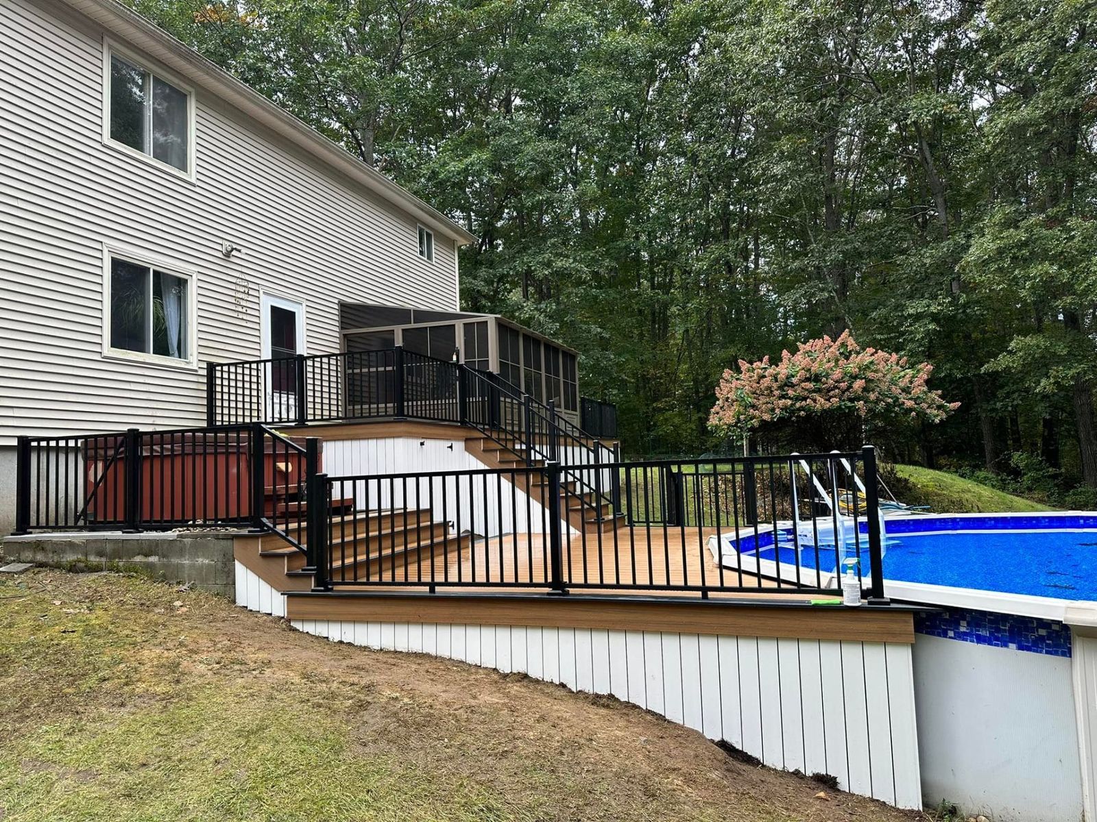 Multi-level pool deck with black railings and composite decking in Southern New Hampshire — 2026 build